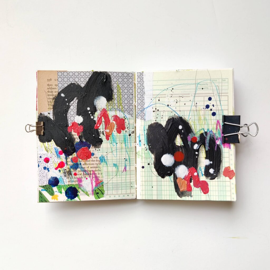 Ingrid Murray's art journal. A layer of collage is in the background, with several big black paint strokes and smaller splotches and scribbles in red, orange, dark and light blue, white, and pink on top.