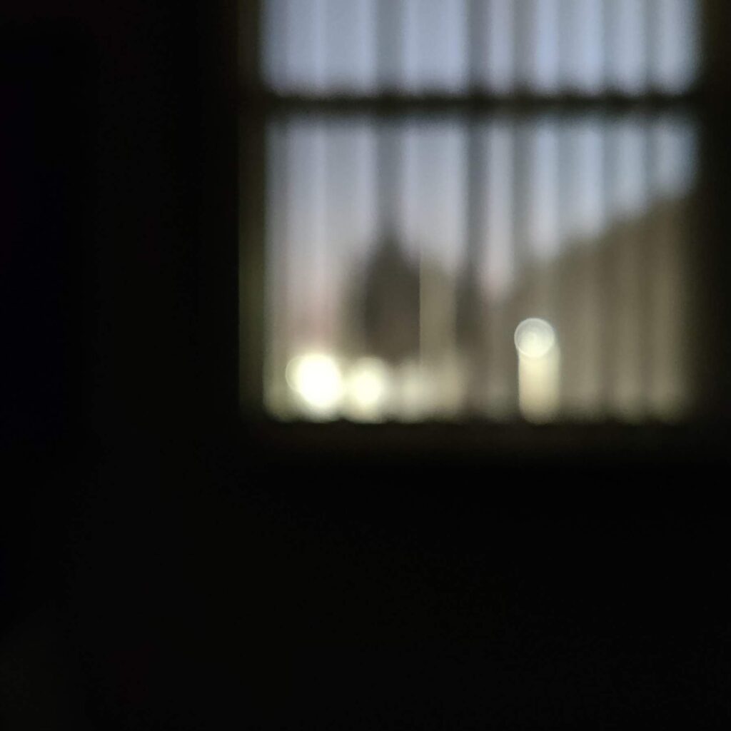 An out-of-focus photo of a dark room and a window.