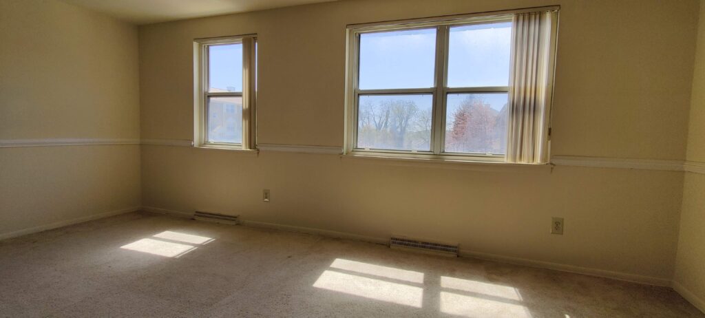 A completely empty room with sunlight shining through the windows.