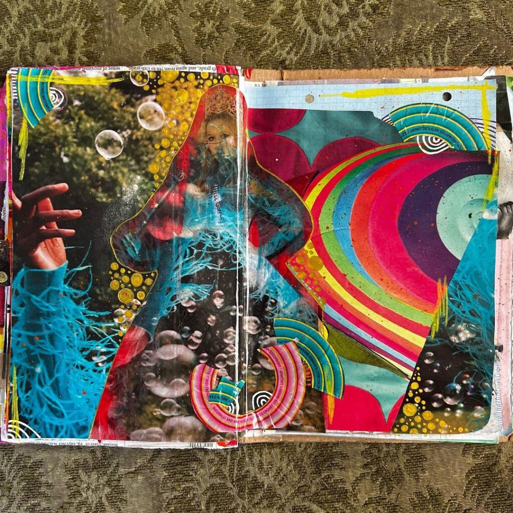An open art journal featuring brightly colored collage.
